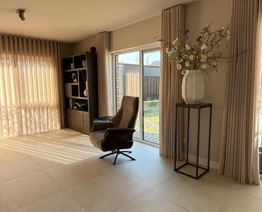 Lichte betonlook tegelvloer van 100x100 cm in een woonkamer in Rijssen Lichte betonlook tegelvloer van 100x100 cm in een woonkamer in Rijssen