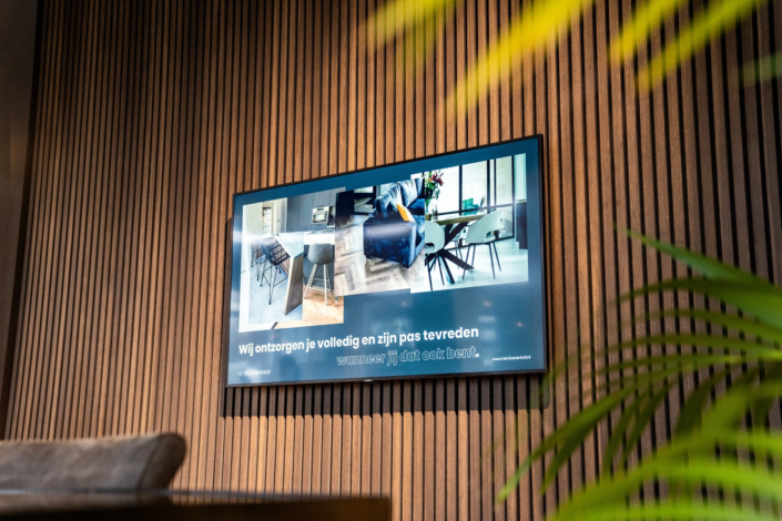 Scherm in de showroom dichtbij Goor met de tekst Wij ontzorgen je volledig