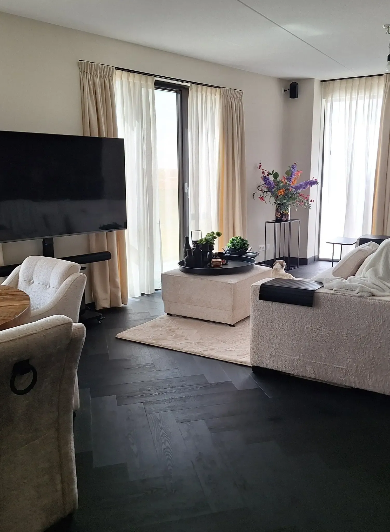 PVC vloeren Winterswijk: donkere PVC visgraatvloer in moderne woonkamer met openslaande deuren PVC vloeren Winterswijk: donkere PVC visgraatvloer in moderne woonkamer met openslaande deuren